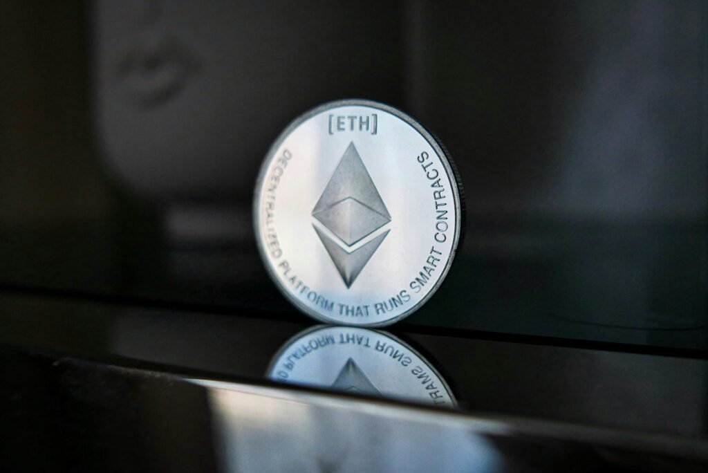 Ethereum logo coin with reflection, symbolizing smart contracts platform, on dark background