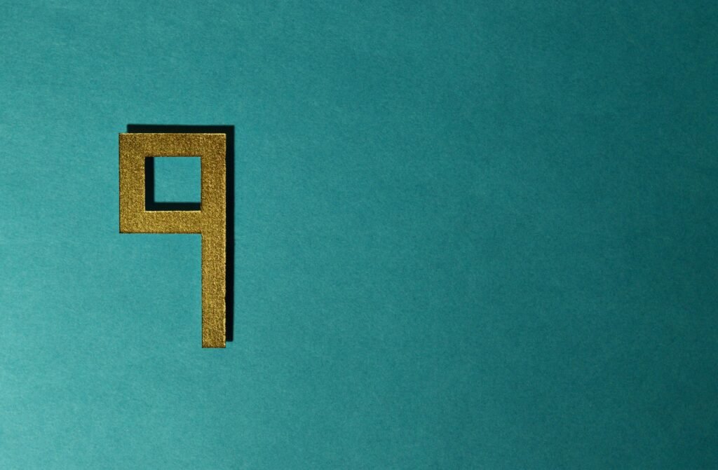 Golden square shape resembling the number nine on a teal background, symbolizing innovation in cryptocurrency.
