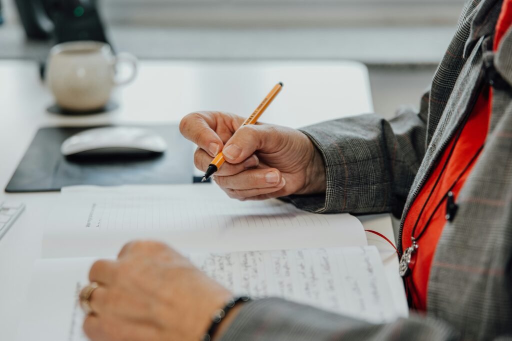 Person writing notes at a desk, reflecting on cryptocurrency trends