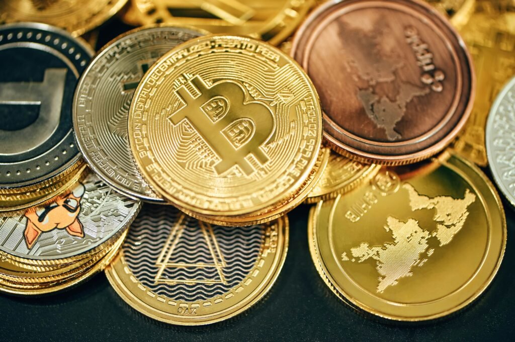 Stack of various cryptocurrency coins including Bitcoin, Ethereum, and others.
