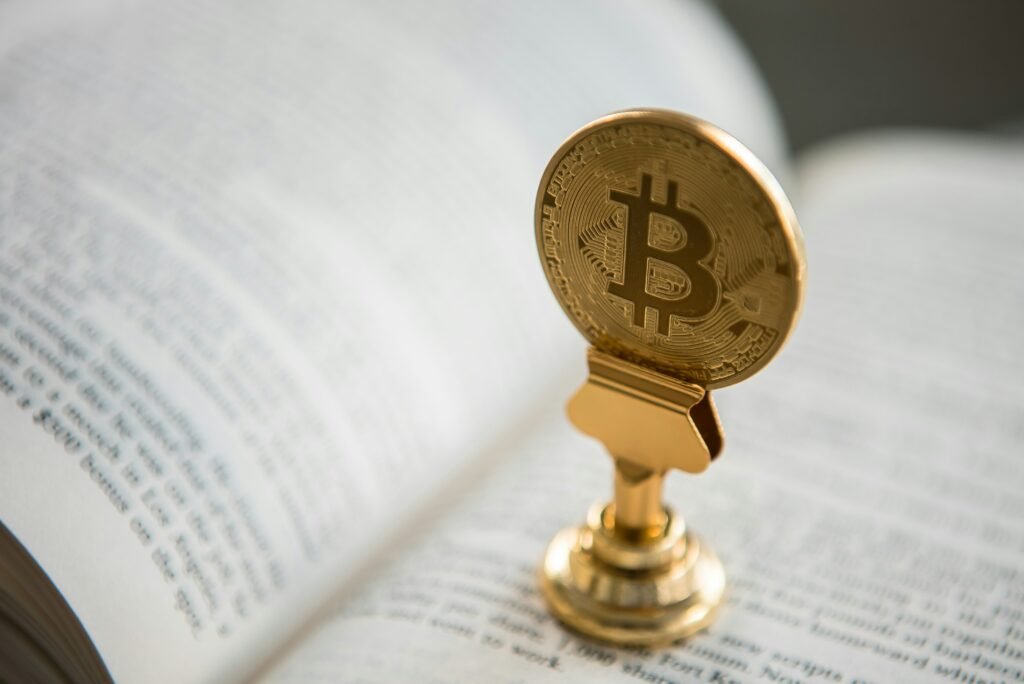 Gold Bitcoin trophy resting on an open book, symbolizing cryptocurrency knowledge