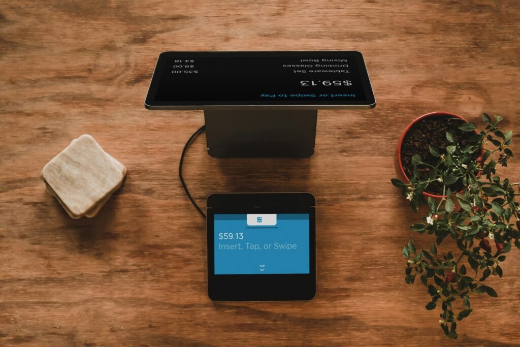 Digital payment display showing $59.13 with options to insert, tap, or swipe on a rustic wooden table.