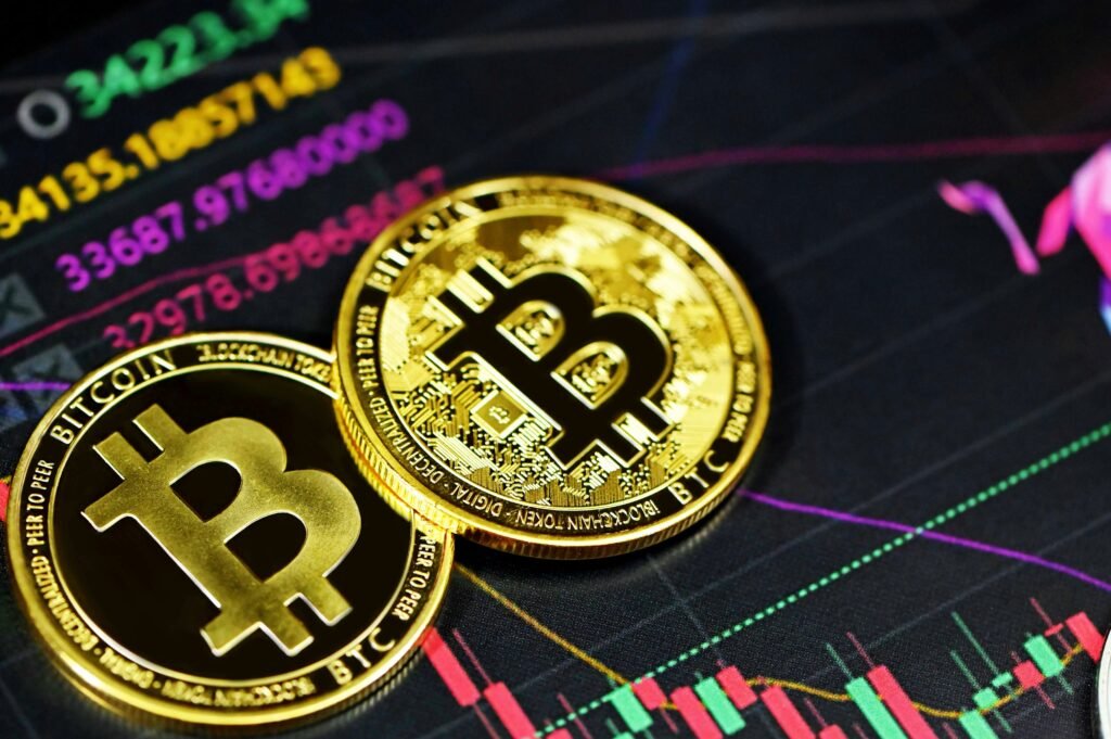 Golden Bitcoin coins on a background of cryptocurrency market charts with fluctuating price graphs