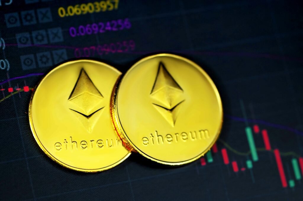 Gold Ethereum coins with digital chart background, illustrating cryptocurrency trends.
