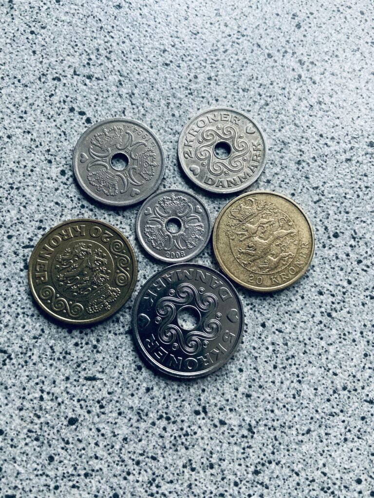 Various Danish coins arranged on a speckled surface.