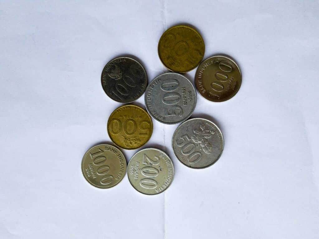 Various Indonesian rupiah coins arranged on white paper