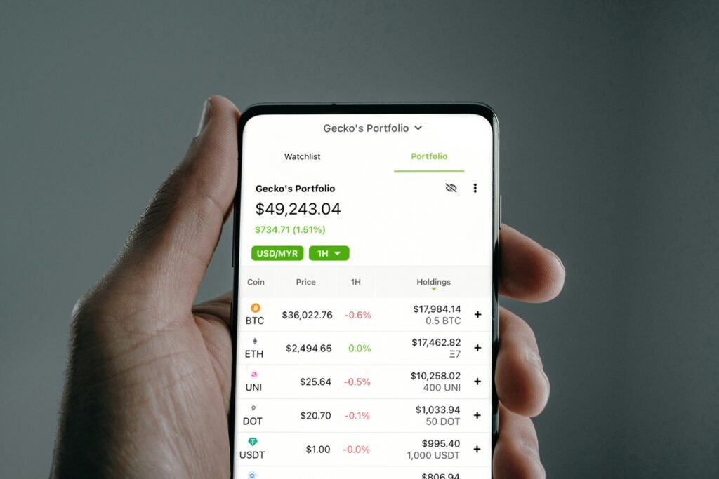 Smartphone displaying a cryptocurrency portfolio with various coin prices and holdings