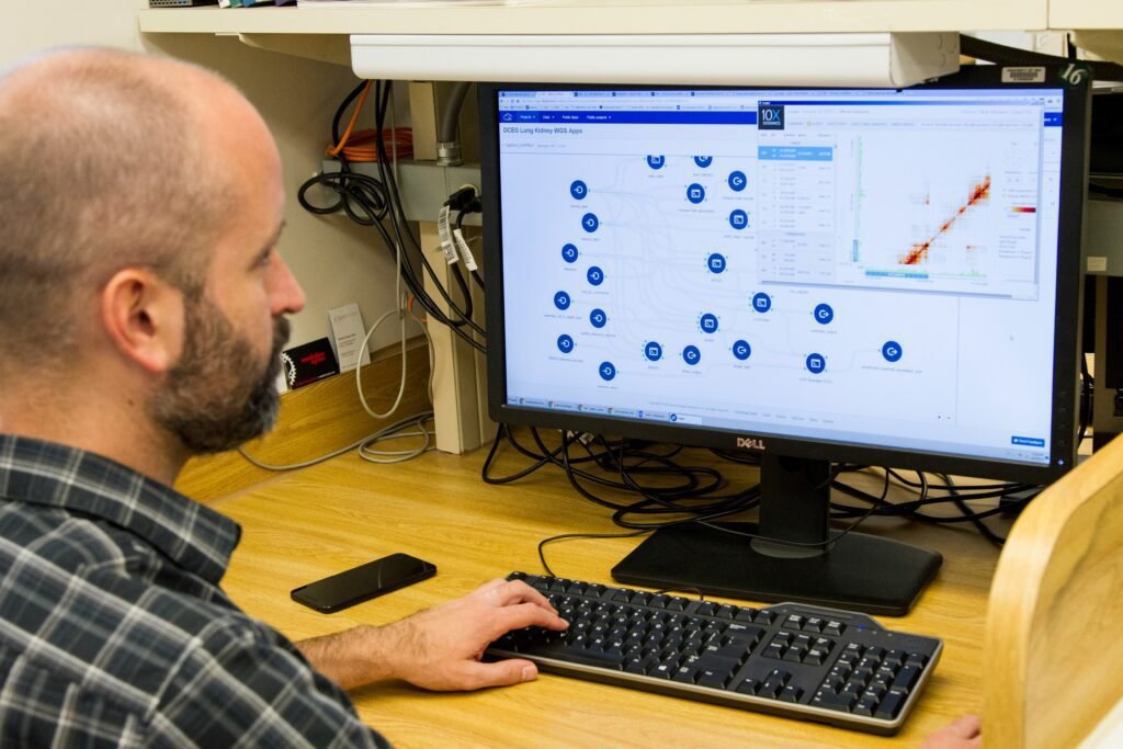Person analyzing data on a computer screen in an office setting.