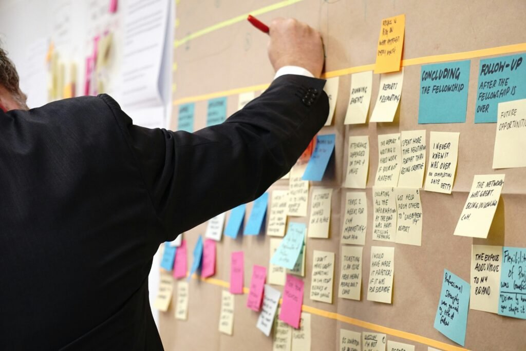 Person in a suit writing on a bulletin board filled with organized sticky notes for cryptocurrency planning.