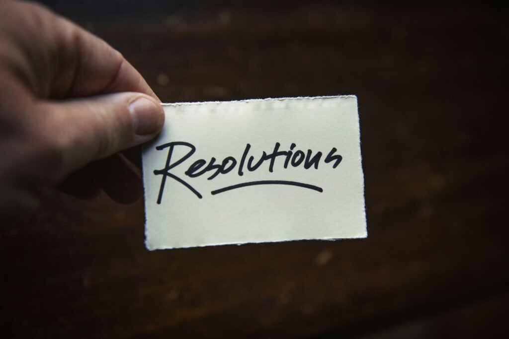 Hand holding a card with the word 'Resolutions' written on it, symbolizing new crypto strategies.