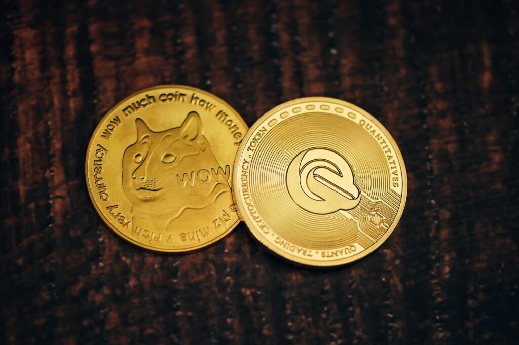Close-up of Dogecoin and a Quant token on a wooden surface